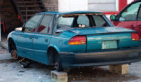 car with missing wheels sitting on cinder blocks